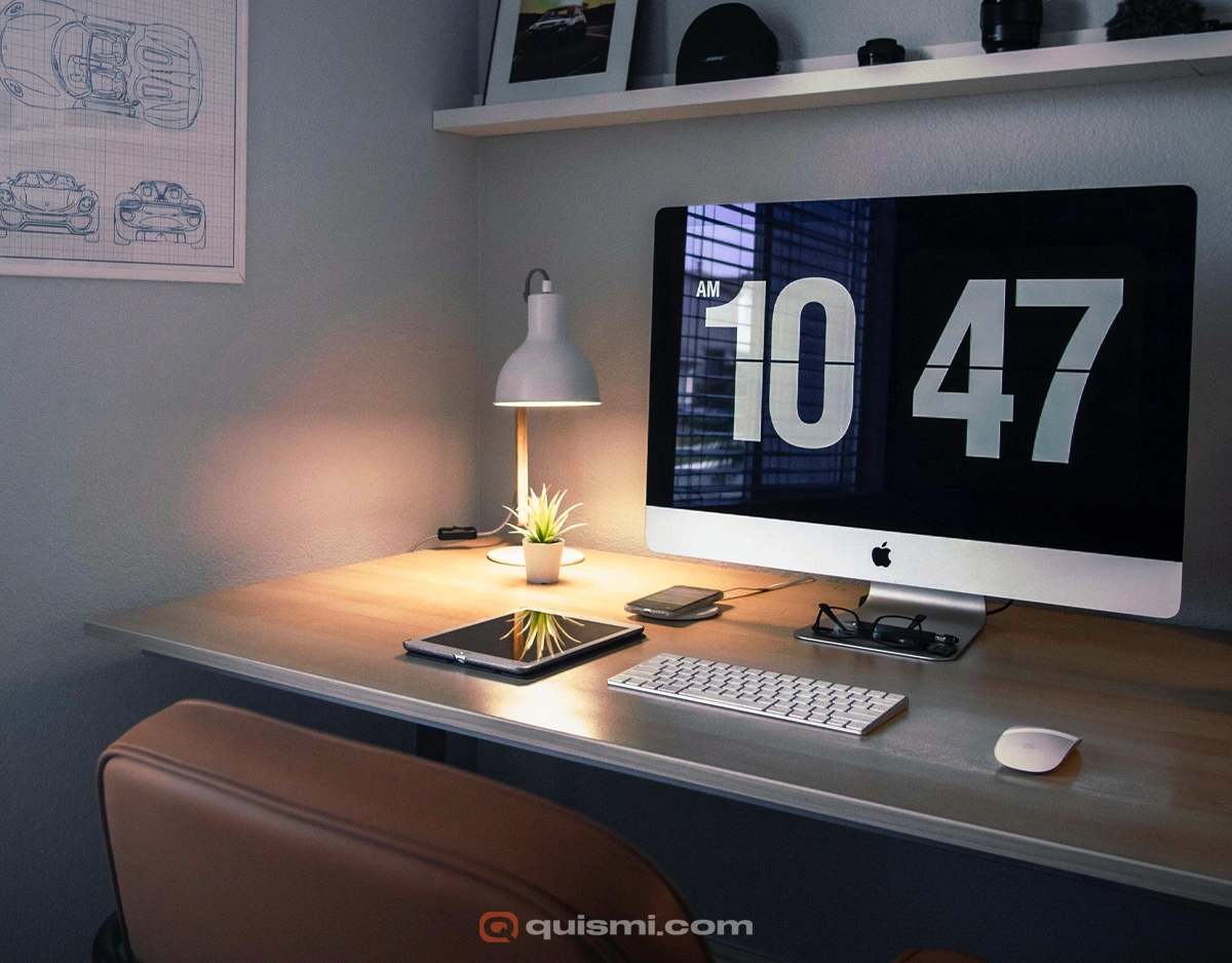 Mac computer displaying Fliqlo flip clock screensaver in a casual home office environment