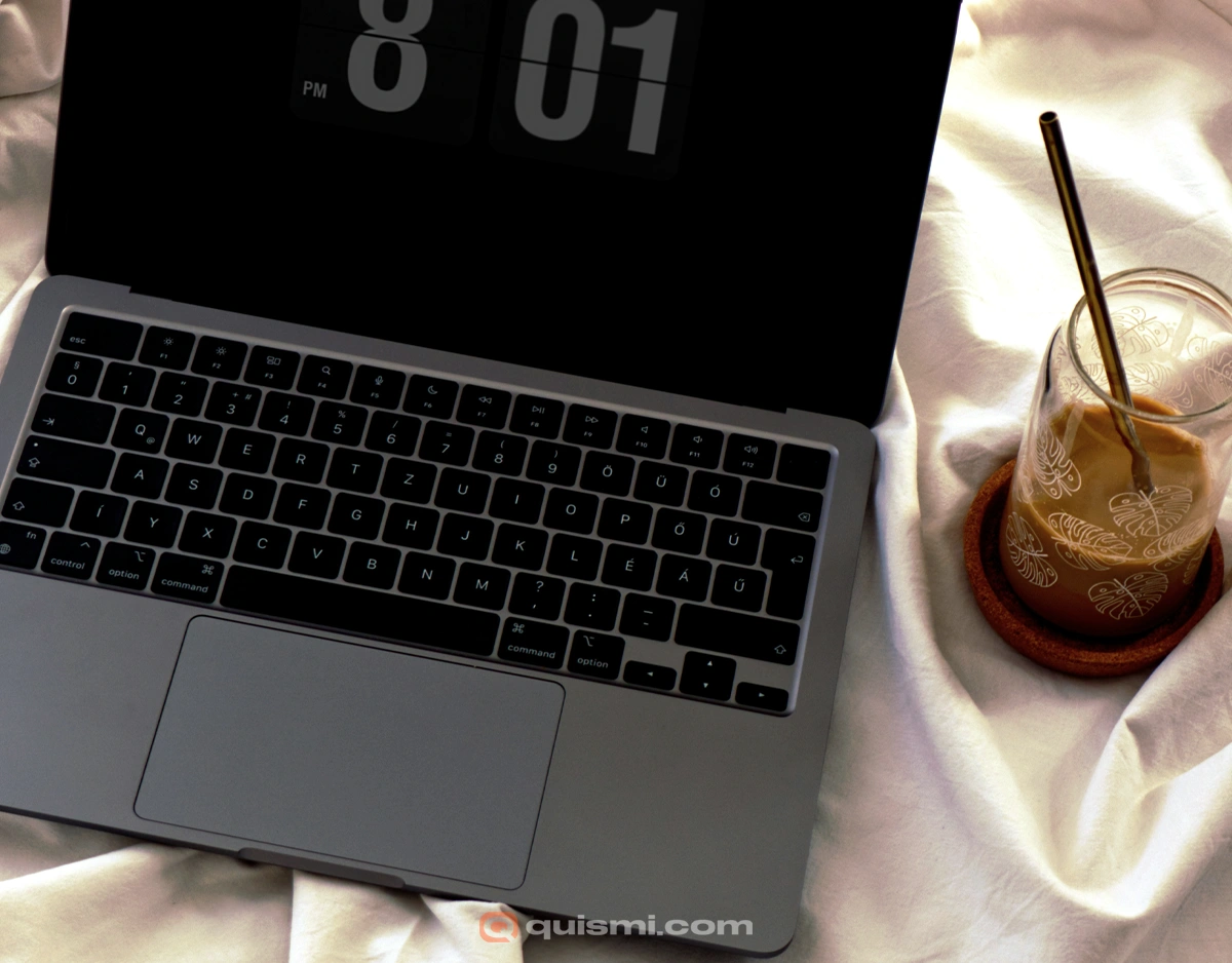 MacBook Pro displaying Fliqlo flip clock screensaver with large white numbers on dark background.