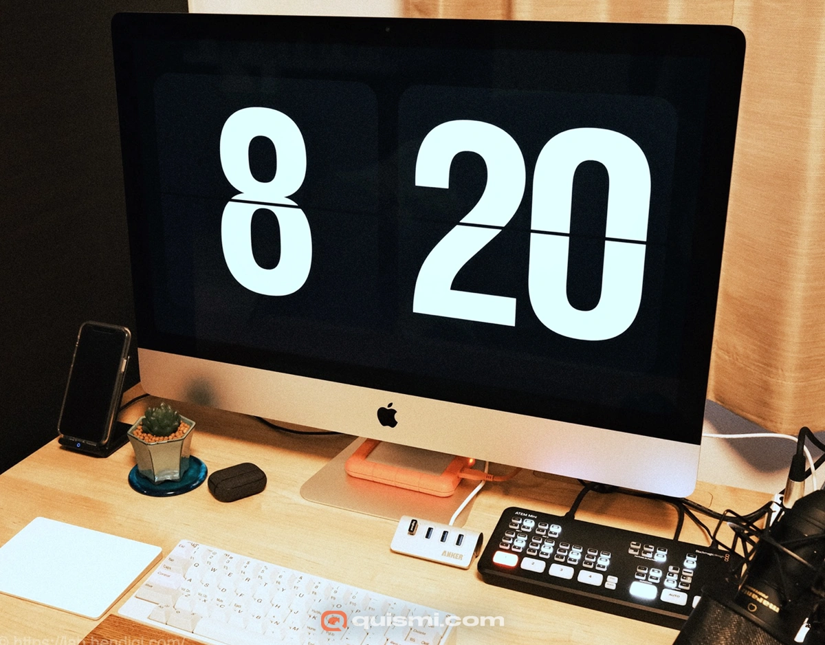 iMac displaying the Fliqlo screensaver, showing a large white flip clock time of 8:20 on a black background.